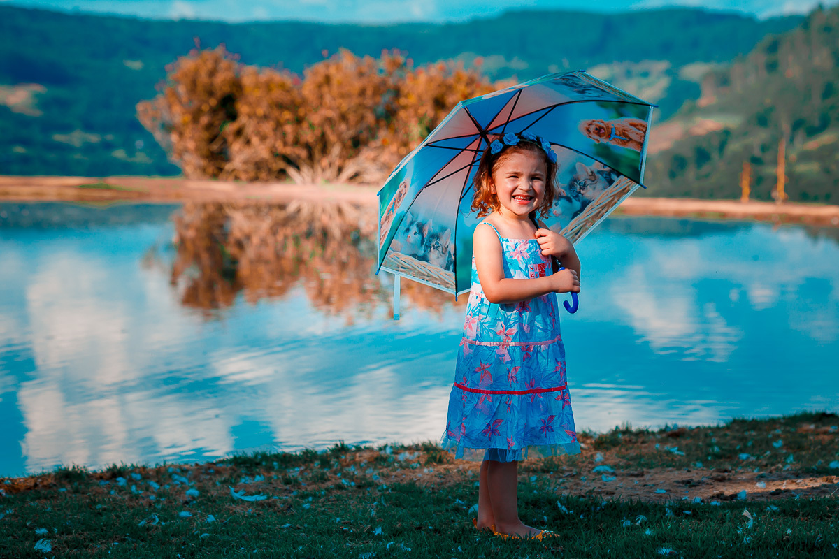 menina na frente do lago com guarda-chuva