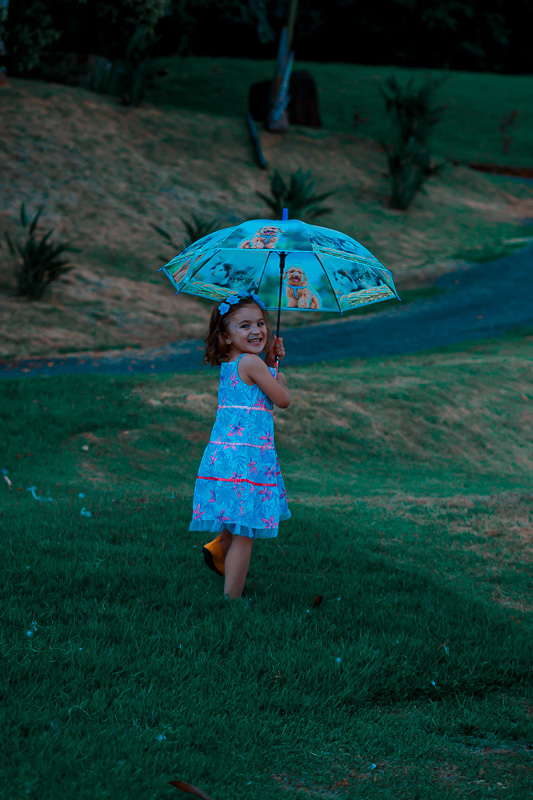 menina correndo de guarda -chuva