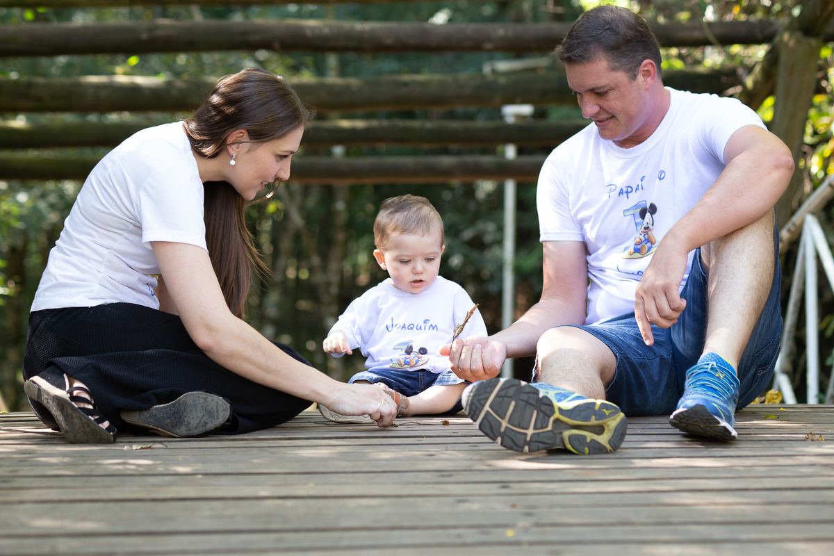 mãe, filho e pai sentados na ponte