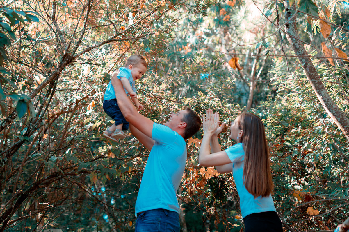 pai erguendo o bebe pra cima e mamãe brincando com ele