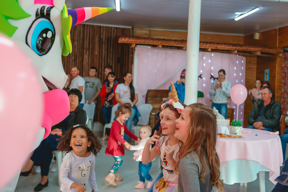 crianças interagindo com o unicornio