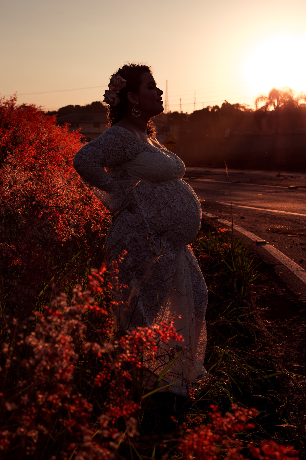 foto de gestante na beira do asfalto no fim da tarde, foto no estilo silhueta