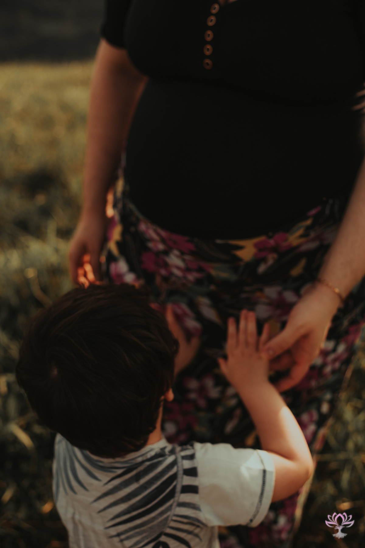 irmão tocando a barriga da mãe gestante
