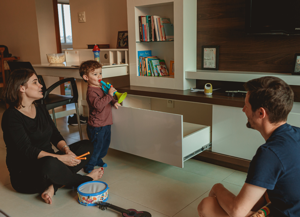 criança tocandp corneta, pais brincado com o filho