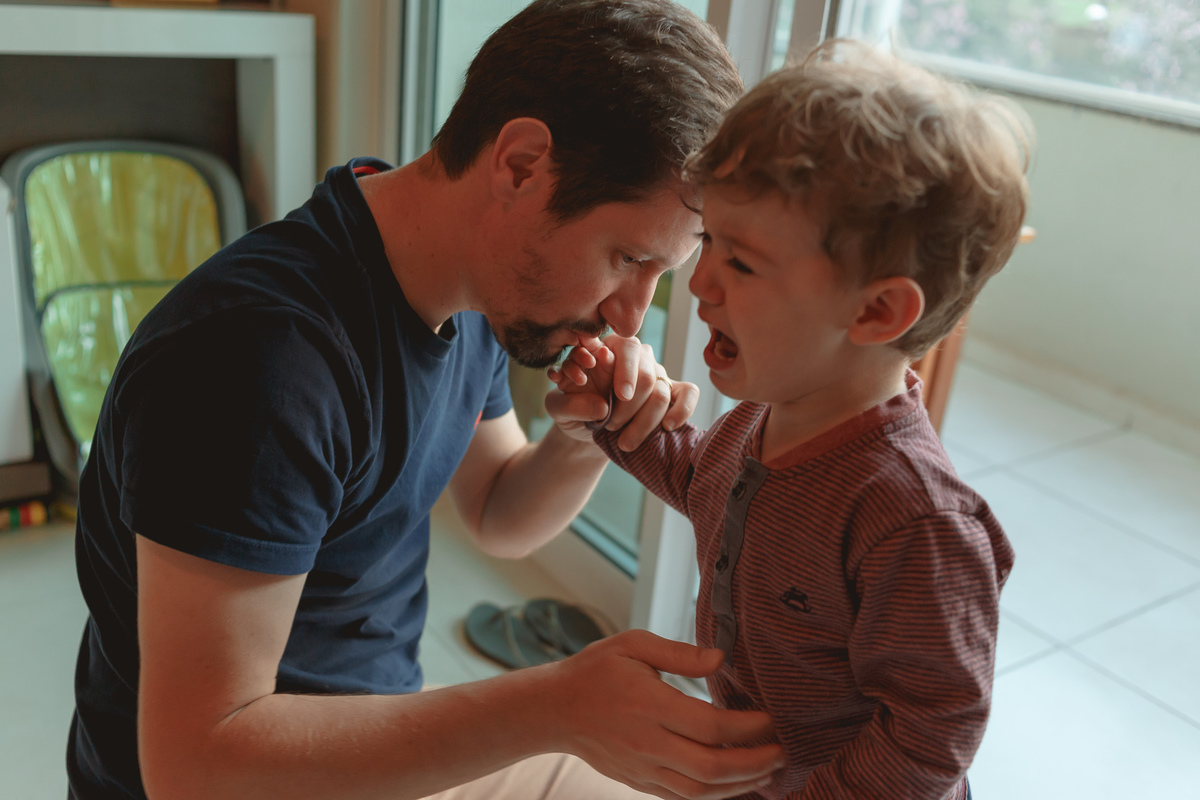 criança machucou o dedo, pai beijando
