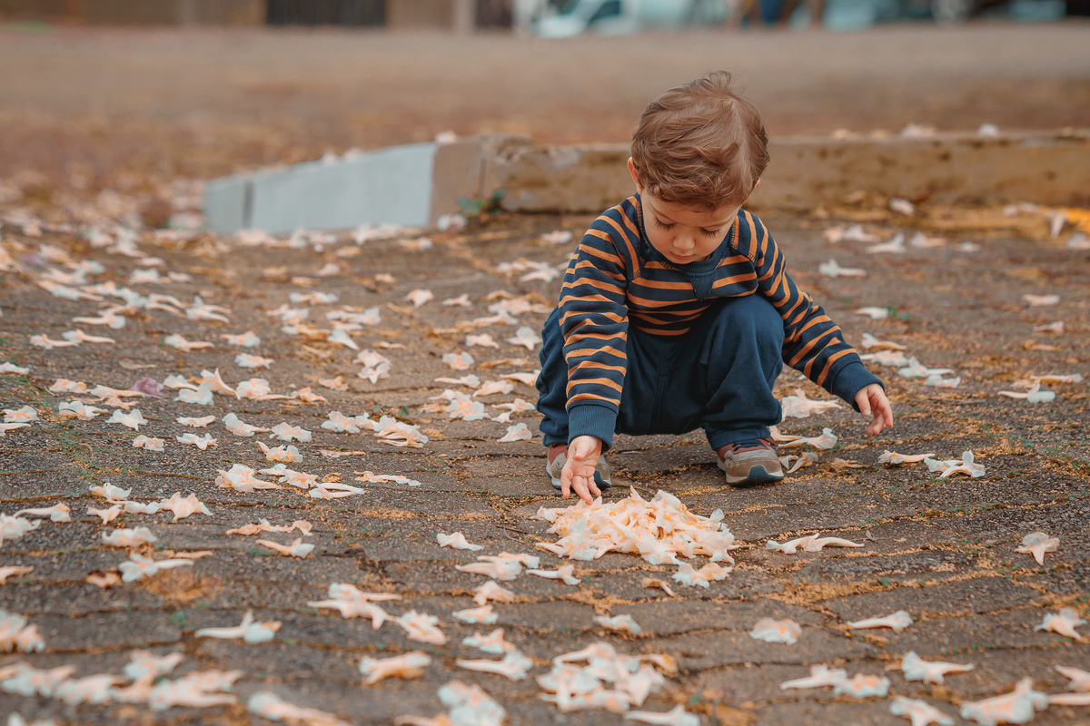 criança brincando com pétalas de flores