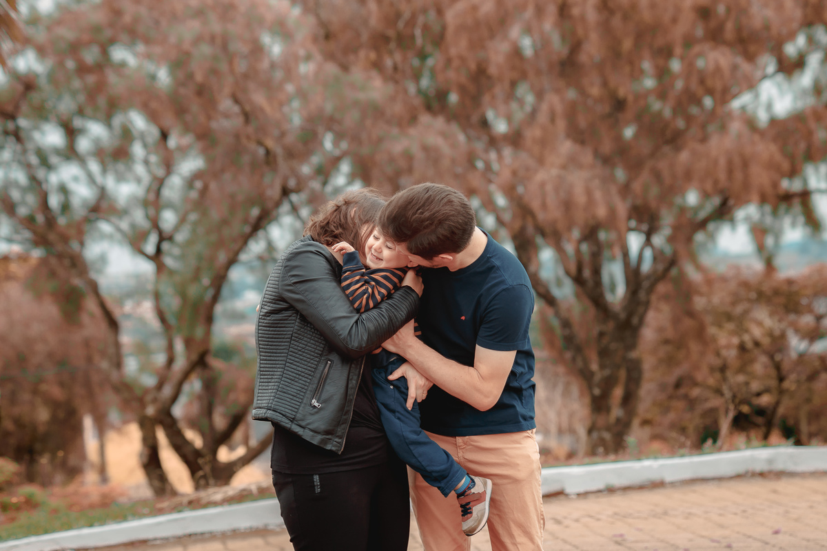 família beijando o filho
