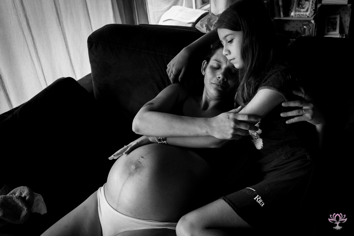 filha abraçando a mae grávida, emocionada.