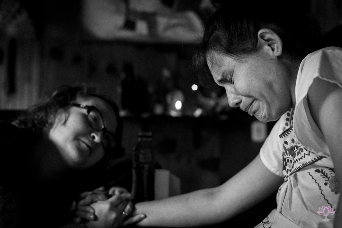 doula emocionada segurando a mão da gestante