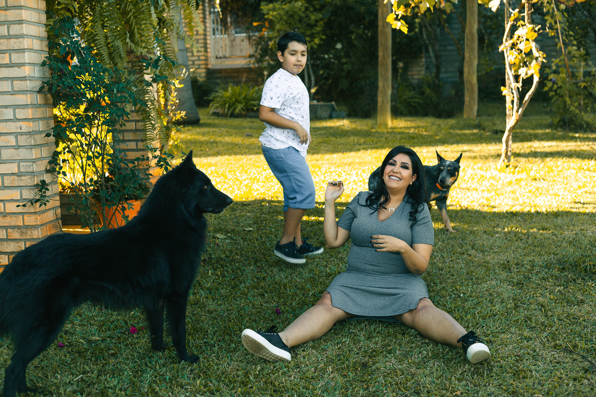 mãe gestante brincando com o filho e os cachorros
