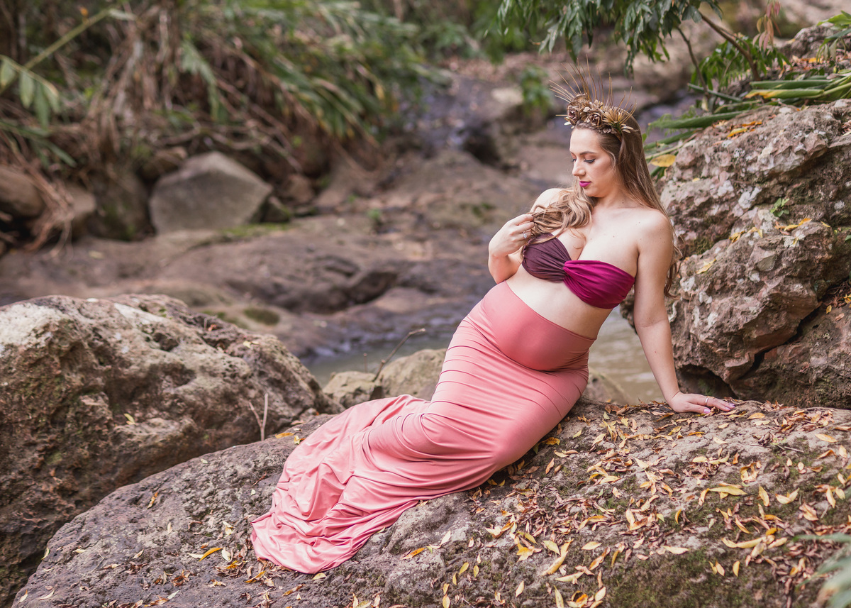 gestante sentada em uma pedra
