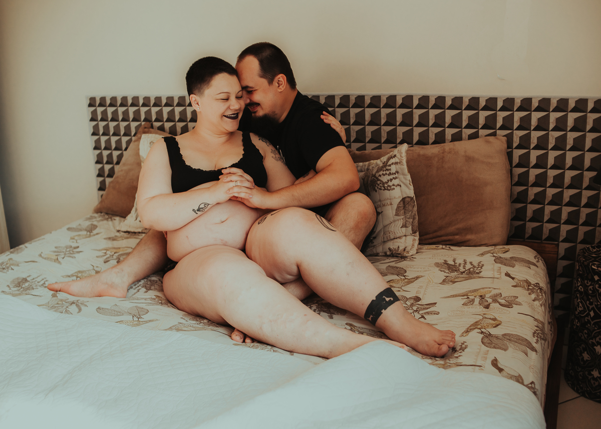 casal gravido na cama
