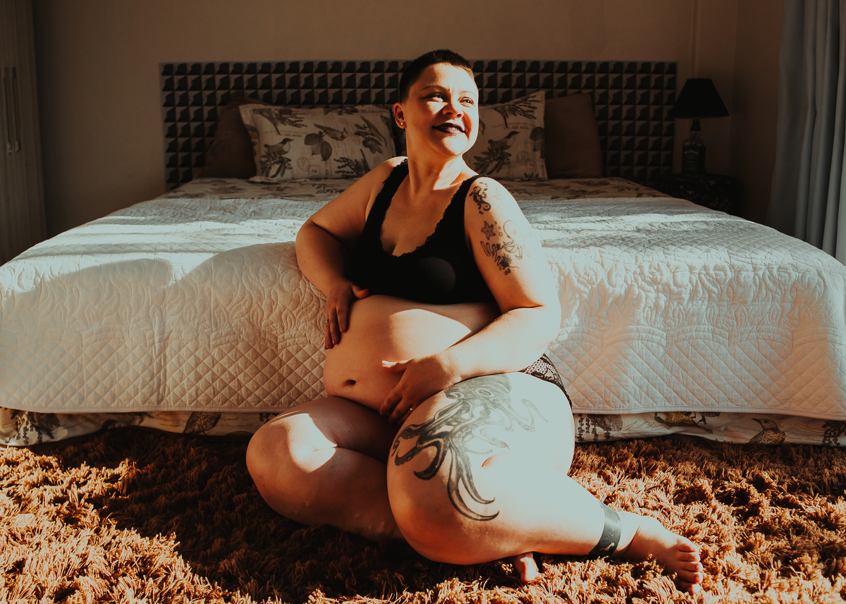 gravida sentada no pé da cama
