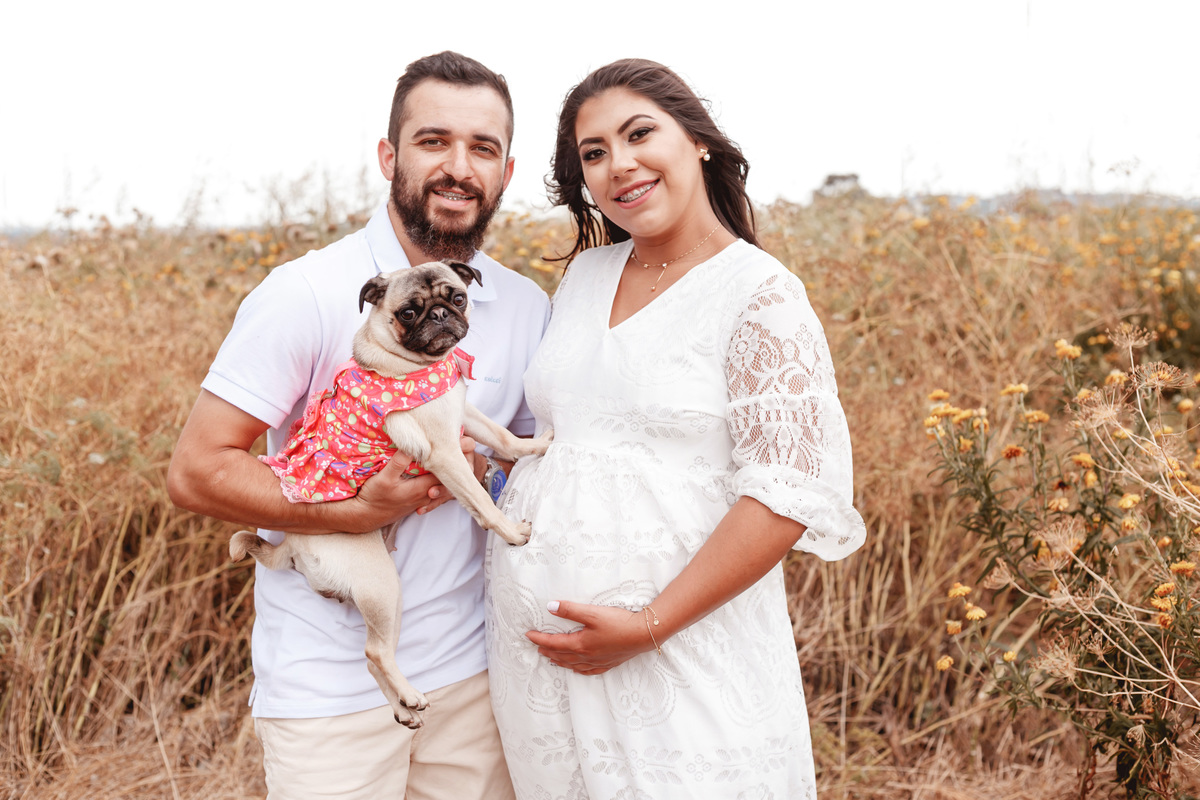 casal gestante posando com seu cachorro pug
