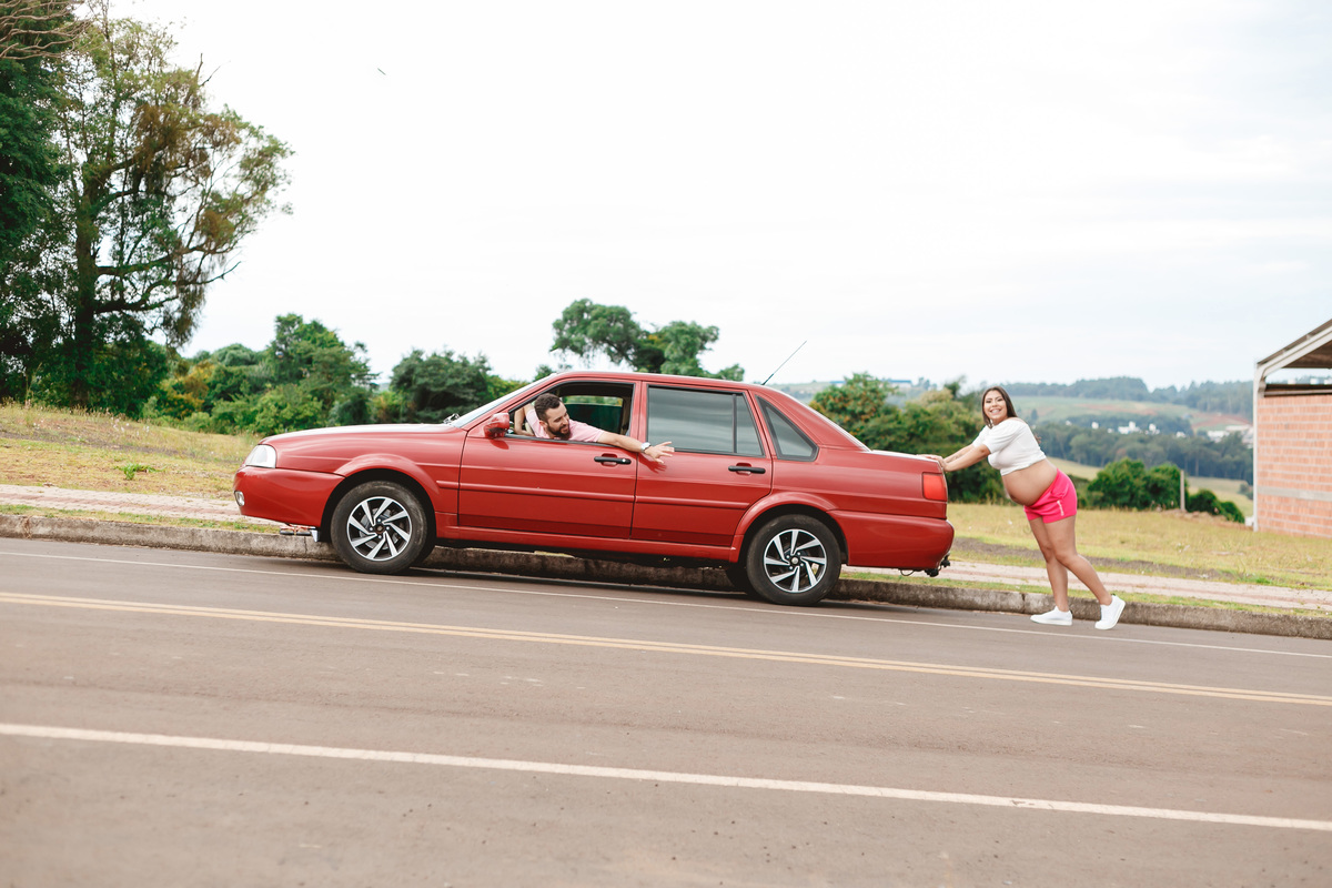 gestante empurrando o carro, um santana vermelho
