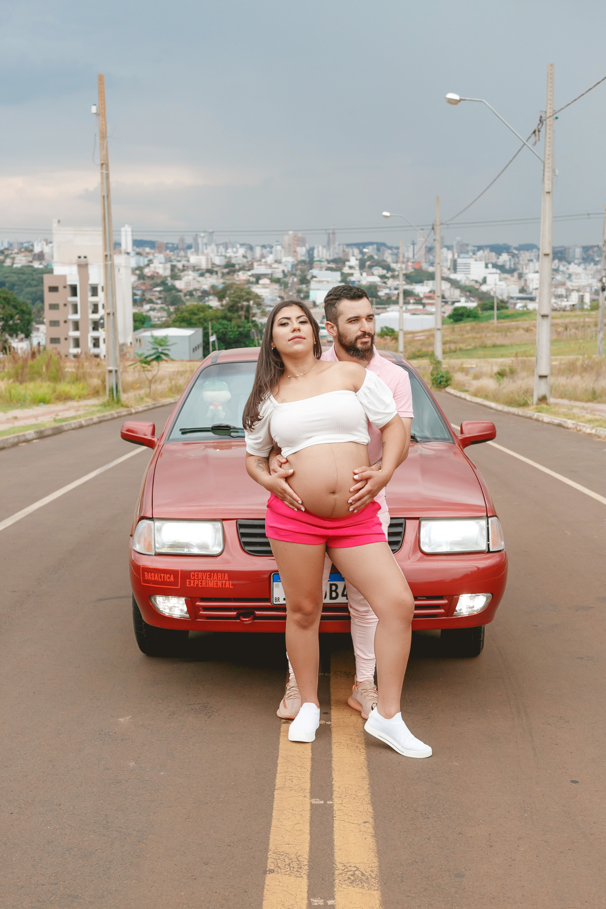 casal posando na frente do carro