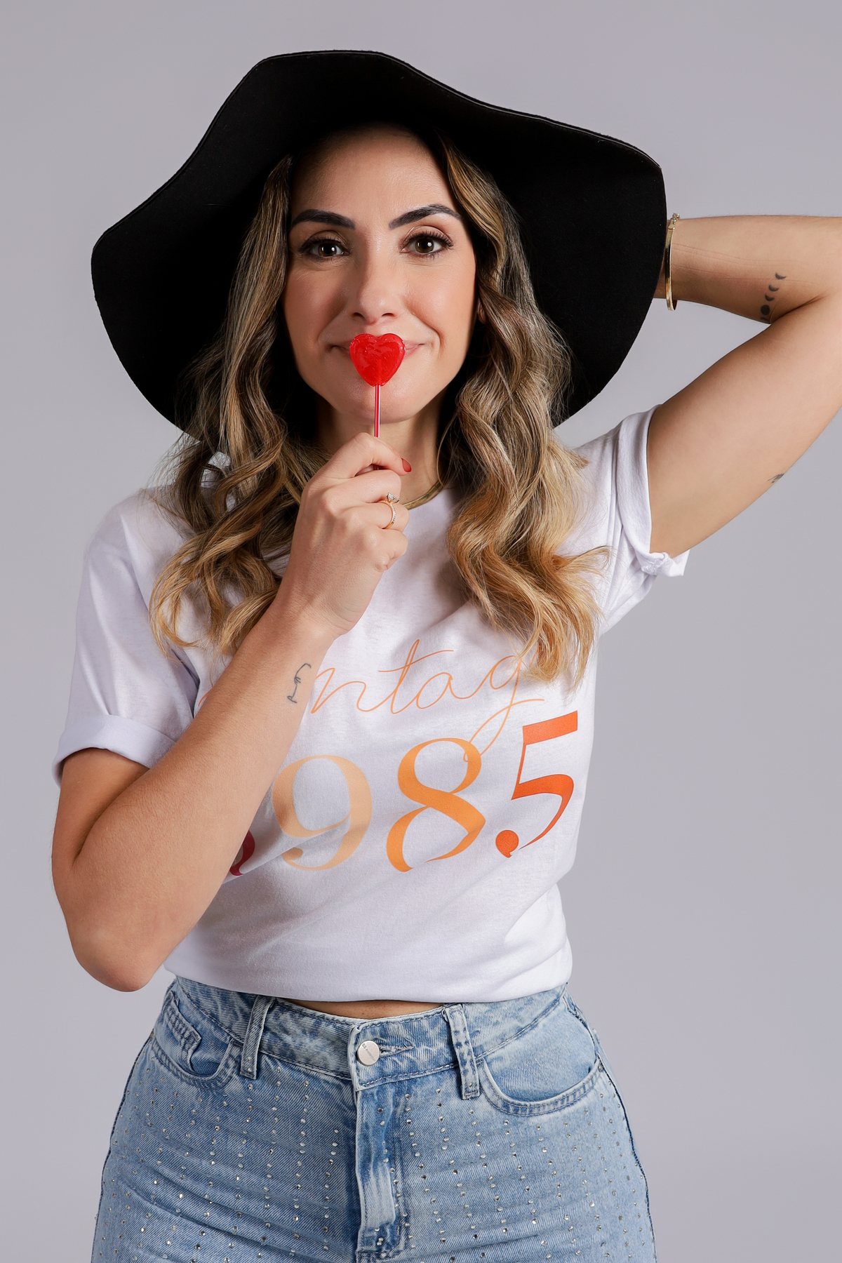 joice com pirulito de coração e chapéu no seu ensaio de aniversário