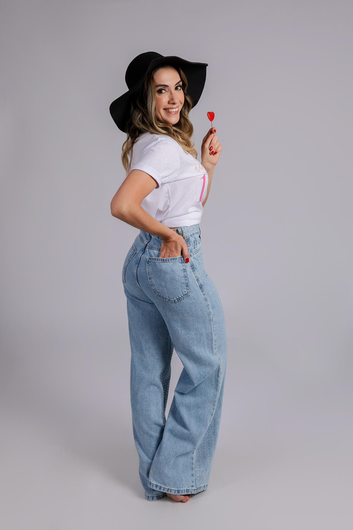 aniversariante no estudio fazendo fotos de aniversário com calça jeans