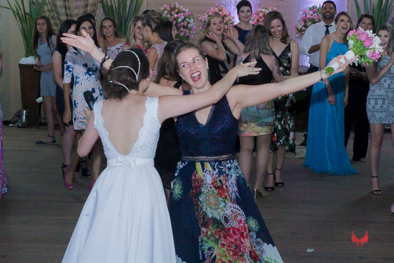 Parkolor fotografias
Gravataí, Glorinha, Santo Antônio
Casamento, hora de tocar o buque, animação das convidadas, vestido branco com renda, decote v nas costas