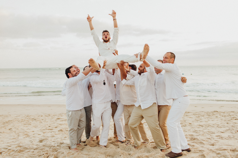 Fotos divertida com os noivos e seus padrinhos. Padrinhos jogando o noivo, fotos na praia, casamento na praia. Fotos por Moyra e Tiago, fotógrafos de casamento