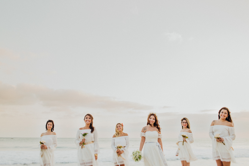 Fotos da noiva com as madrinhas. Esse casamento na praia teve uma luz incrível. A Mayara e suas amigas de branco ficaram lindas. Fotos do Tiago nesse casamento intimista. Casamento em São Sebastião na Praia de Santiago.