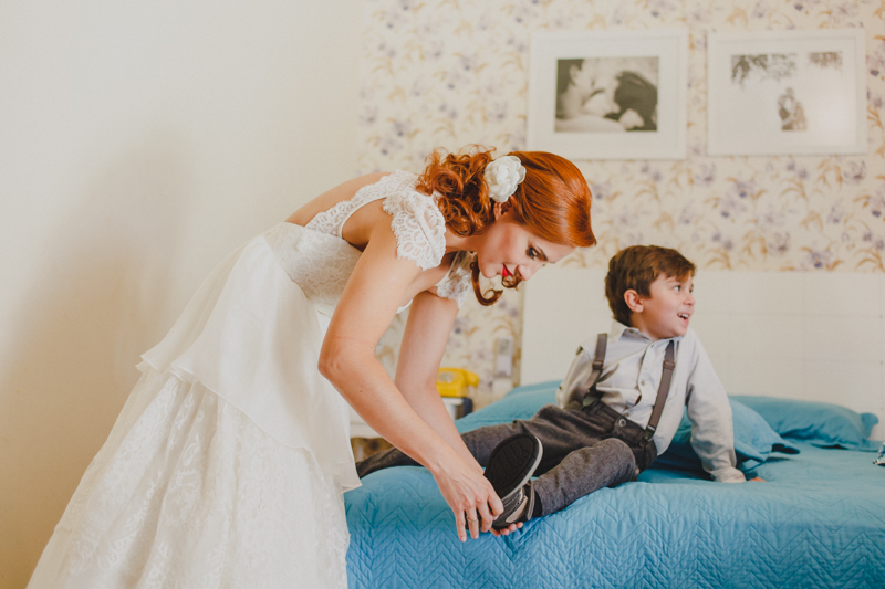 A noiva Helena se arrumou em casa junto com seus filhos. Depois da noiva estar pronta ela ajudou a preparar seus filhos para o casamento. A noiva arrumando o seu filho antes do casamento.