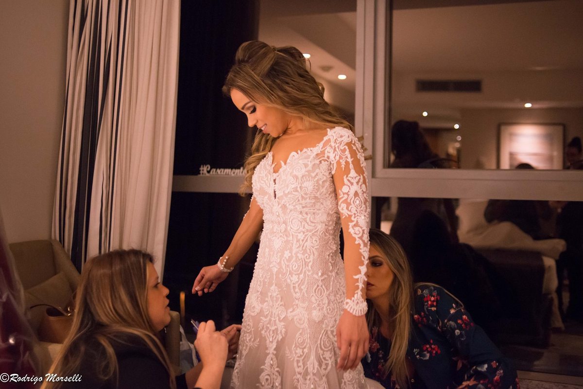 estilistas fazendo ultimo ajuste no vestido da noiva