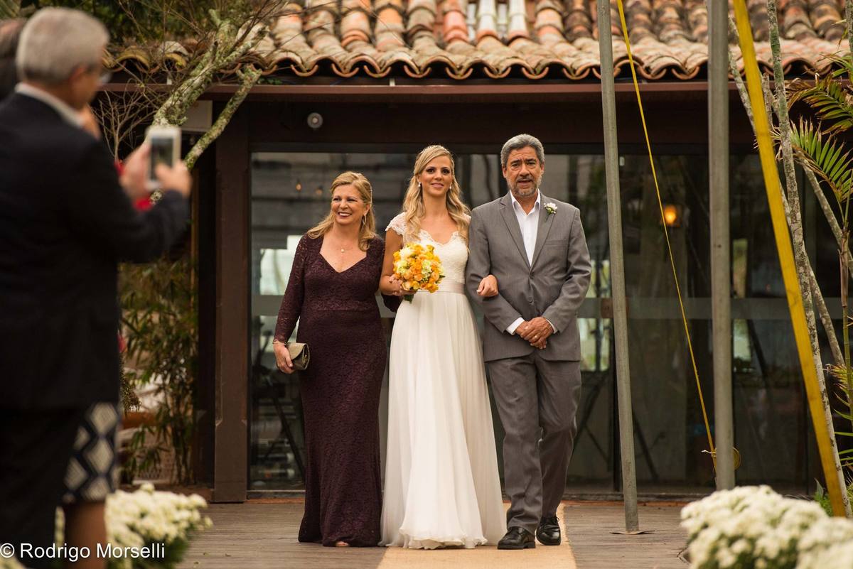 noiva entrando com seus pais na cerimonia na praia em búzios