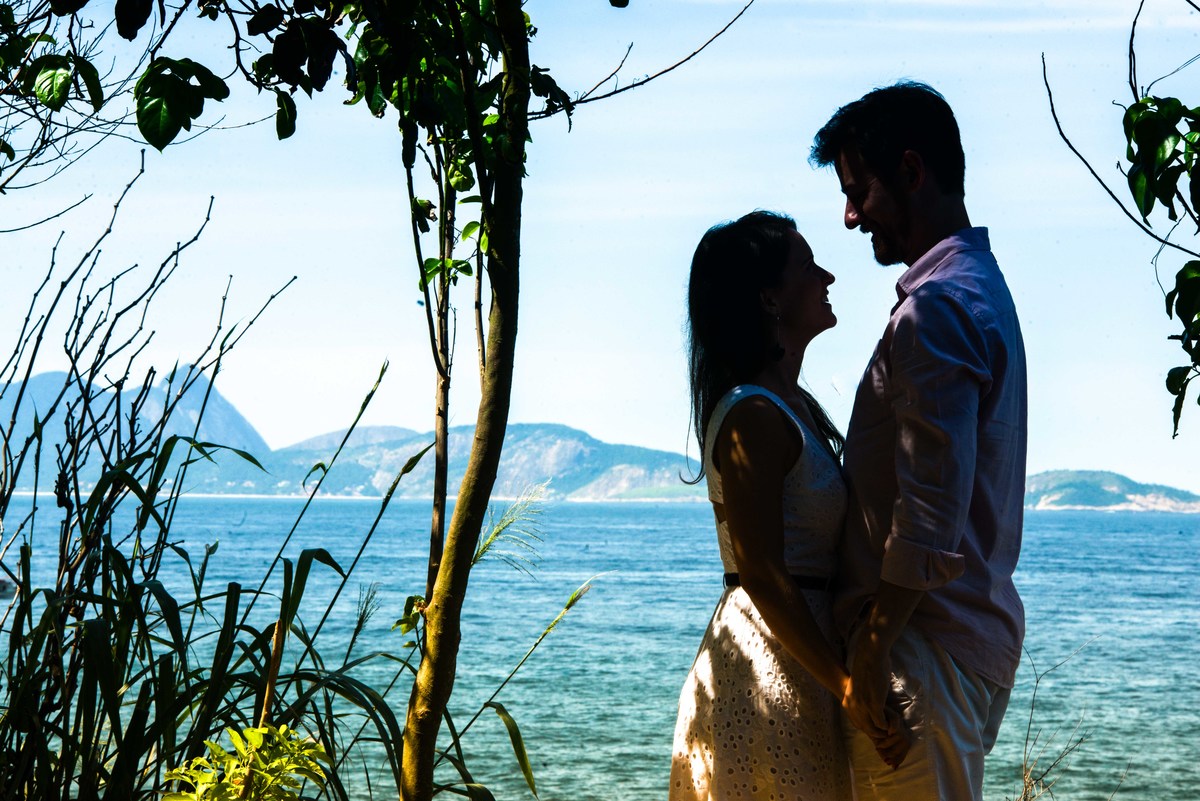 casal parado diante do mar da Urca