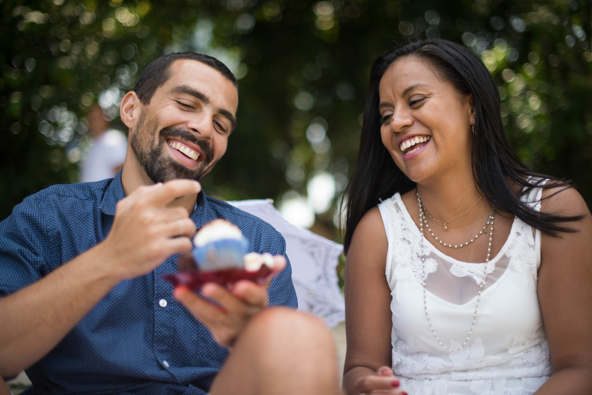 noivos compartilhando cupcake no ensaio de casal