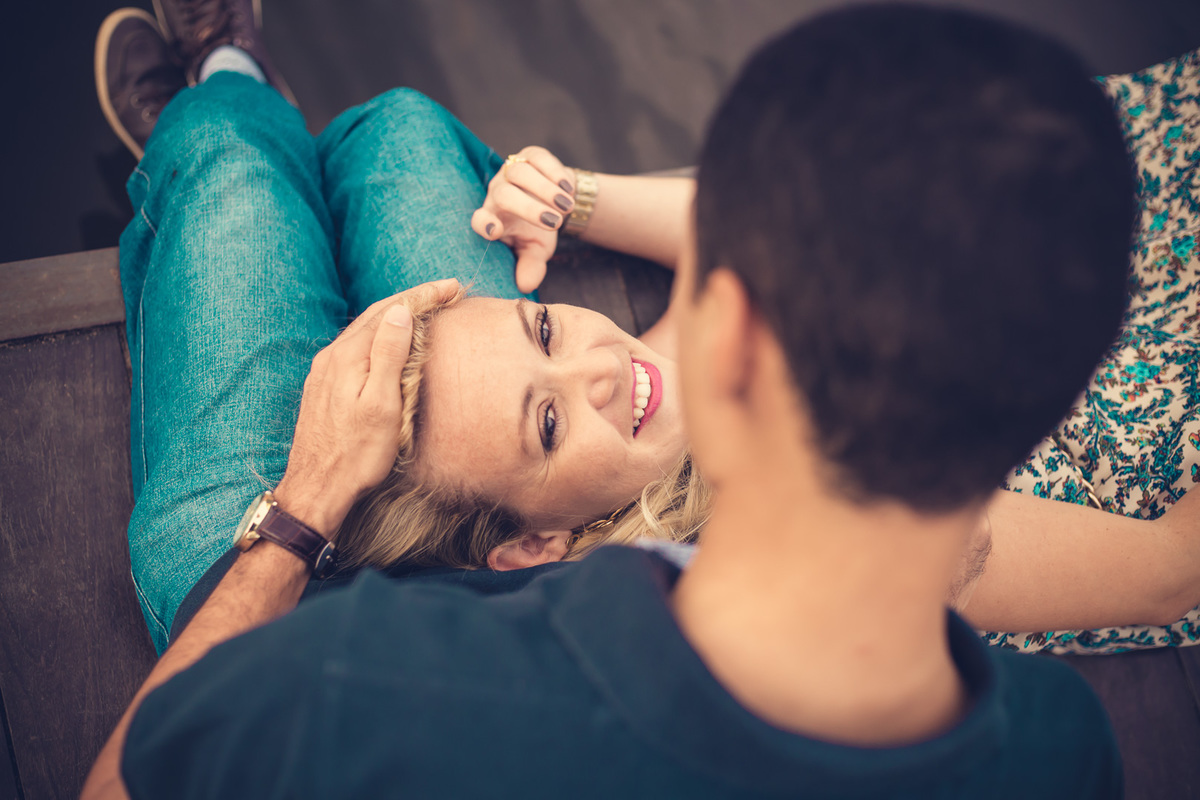 Fotografia de casal, ensaio pré-casamento, noiva deitada no colo do noivo namorando no Parque de Pituaçu, Salvador - BA