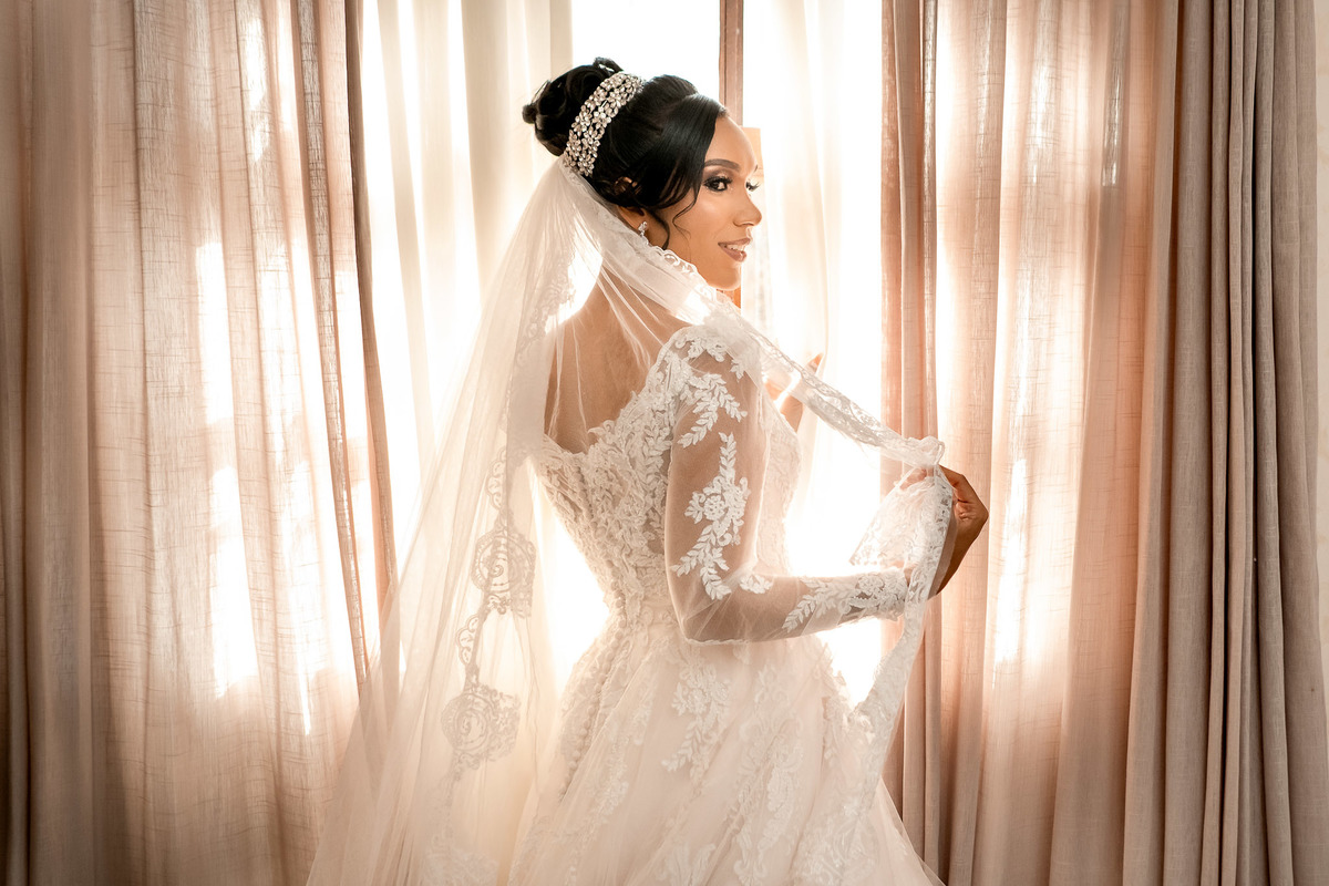 Noiva tirando foto na janela de costas no Sítio Canto Verde,  casamento Lauro de Freitas com elegância.