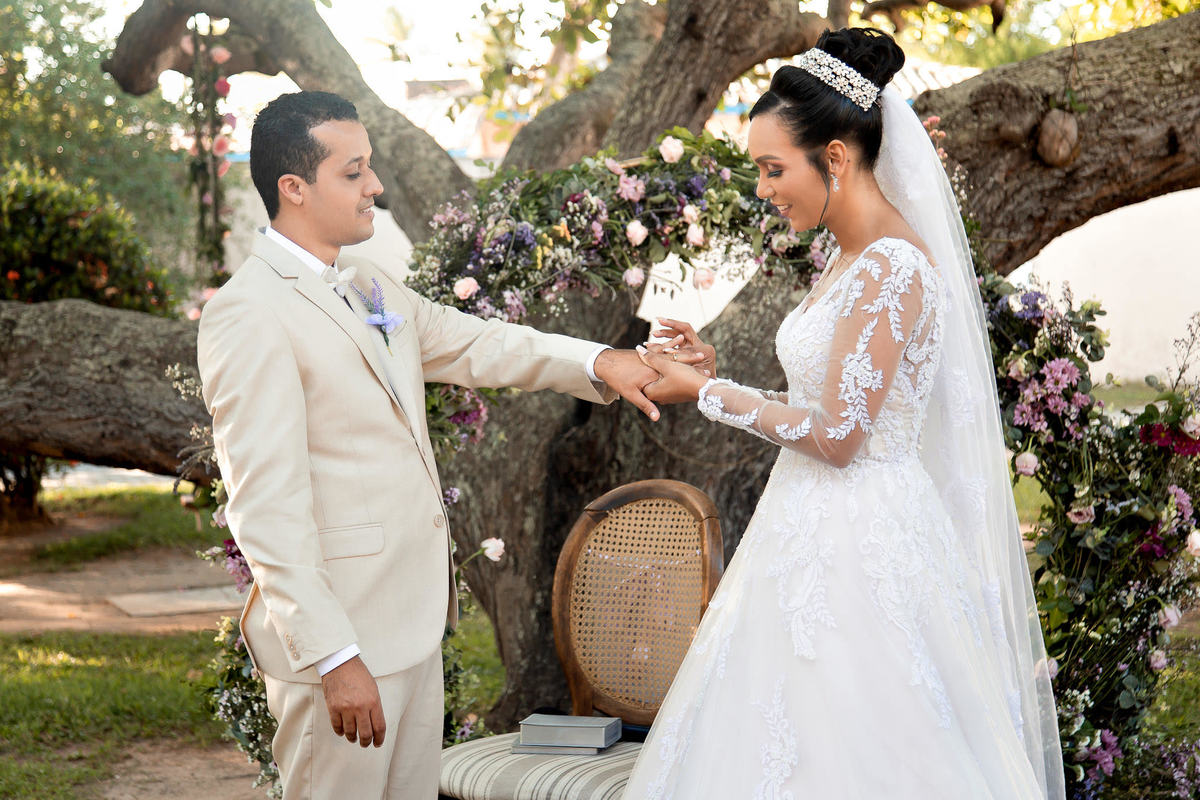 Cerimônia de casamento no Sítio Canto Verde, noivos trocando alianças em Lauro de Freitas com emoção.