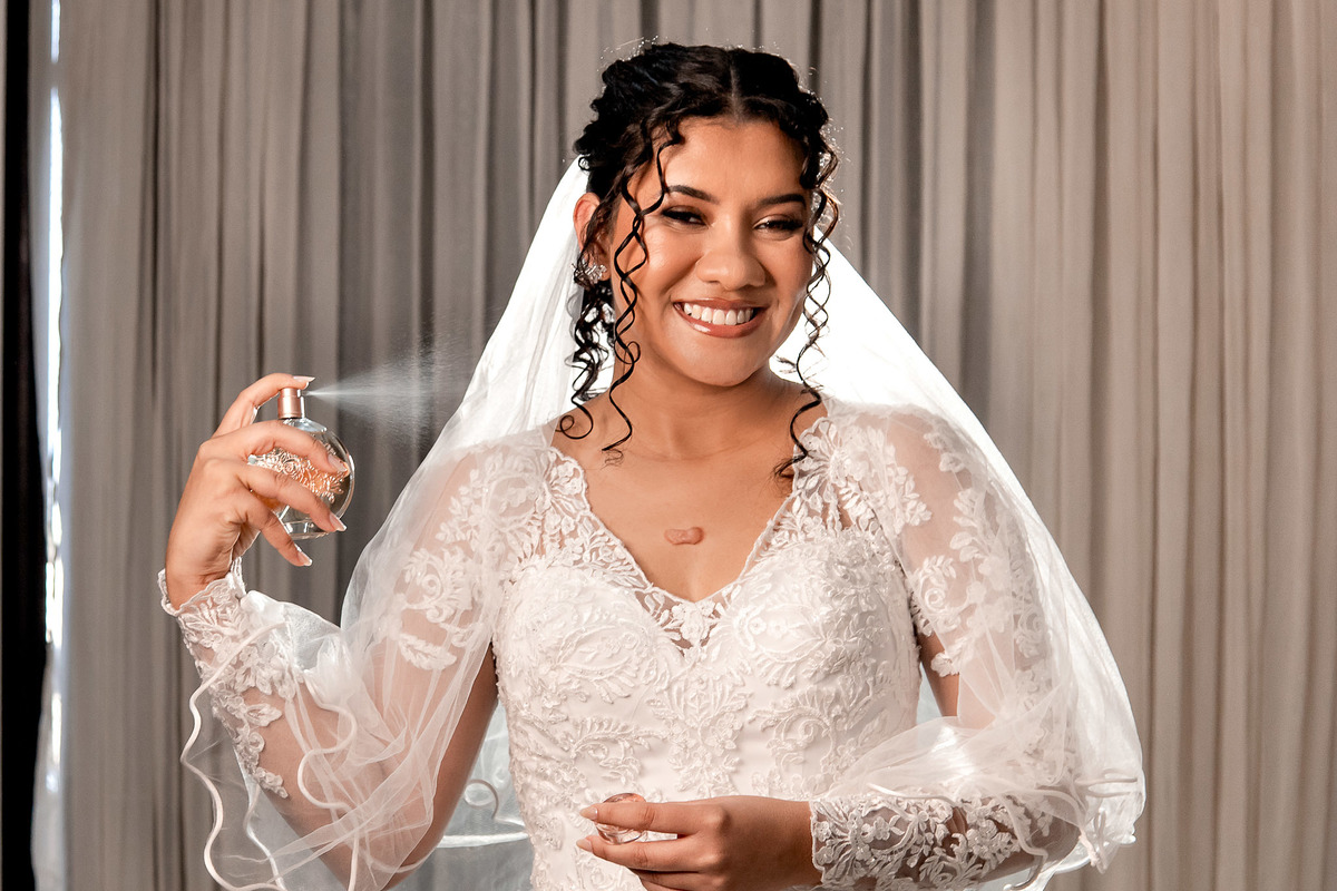 Foto da noiva pronta, passando perfume, casamento em Salvador no Salão do Reino em Pernambués.