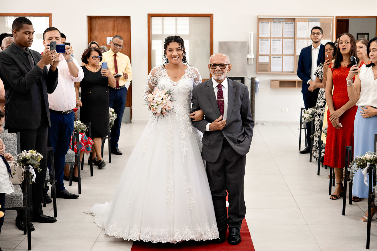 Noiva entrando de braços dados com o pai, caminho até o altar no casamento em Salvador.