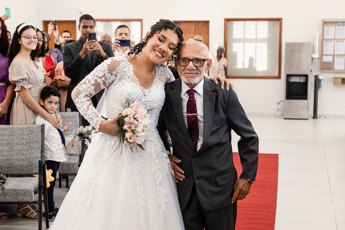 Noiva se despedindo do pai no altar, momento sensível do casamento no Salão do Reino em Pernambués.