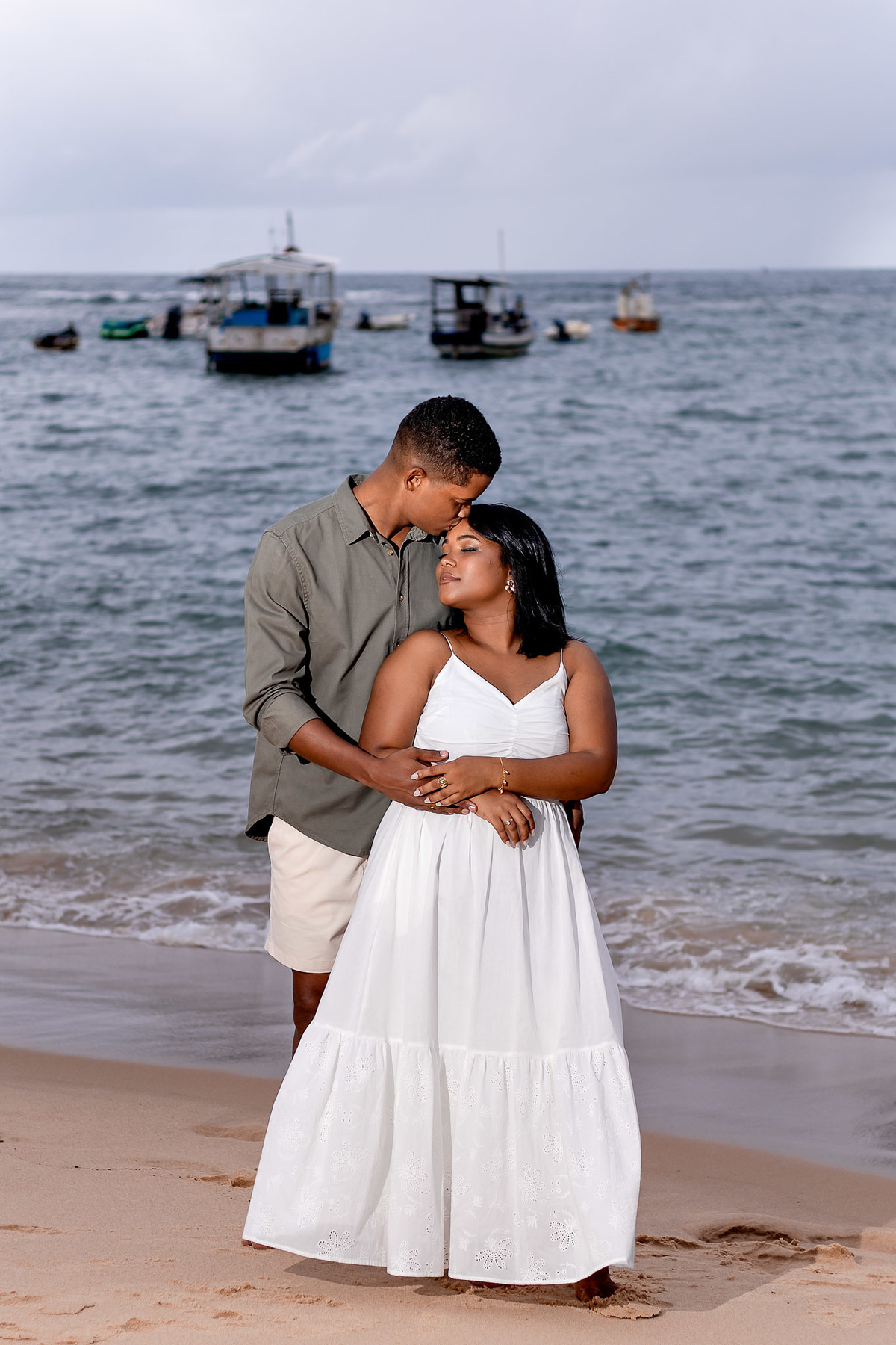 ensaio pré-casamento beijo testa casal Bahia, fotografia abraço romântico praia Salvador, ensaio pré-nupcial momento carinhoso Praia do Forte, fotografo casamento carinho Bahia, fotografia ternura casal noivos praia, ensaio casal pose abraço Bahia, beijo 