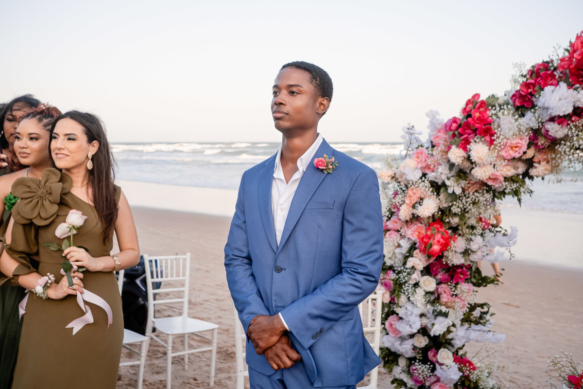 Noivo aguardando a noiva no altar de flores durante casamento na Praia do Flamengo