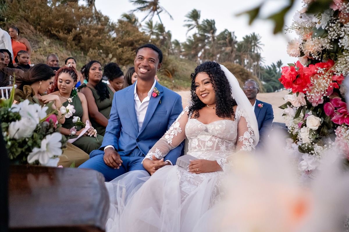 Noivos rindo juntos durante a cerimônia de casamento na praia em Salvador