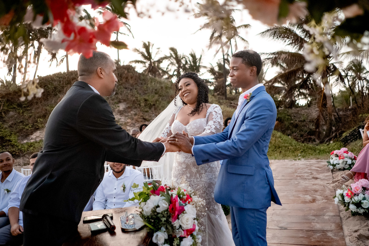 Celebrante parabenizando os noivos ao final da cerimônia de casamento na praia