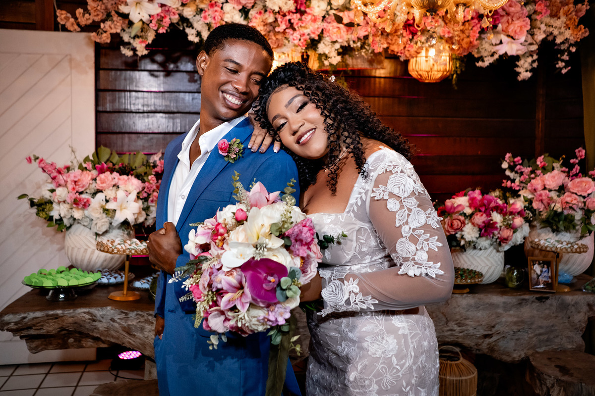 Noivos abraçados com buquê de flores durante a festa de casamento em Salvador