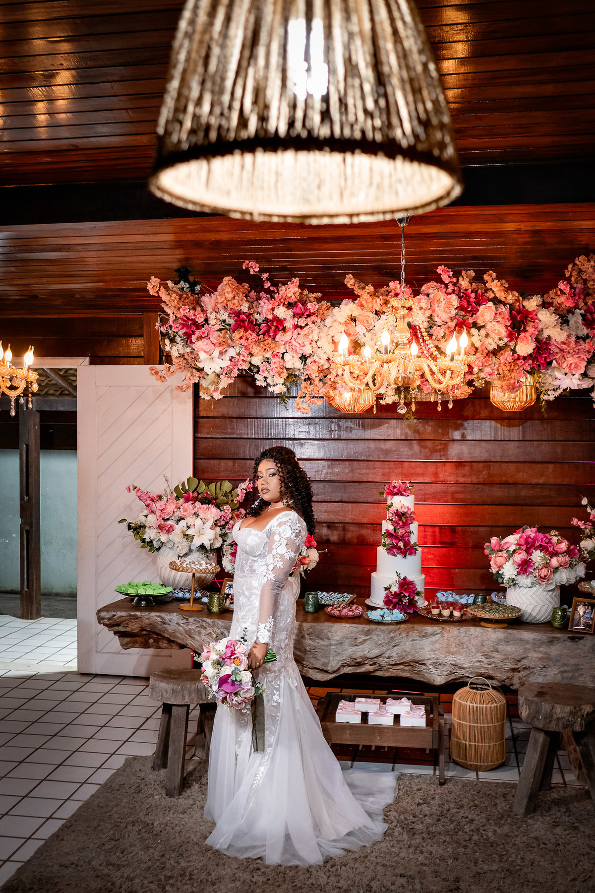 Noiva posando ao lado da mesa de doces na festa de casamento em Salvador
