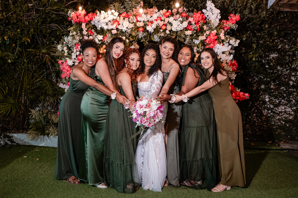 Noiva com as madrinhas segurando o buquê na festa de casamento em Salvador