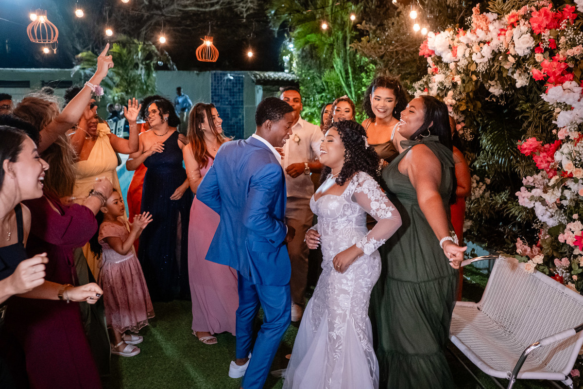 Convidados dançando sob luzes decorativas na festa de casamento em Salvador