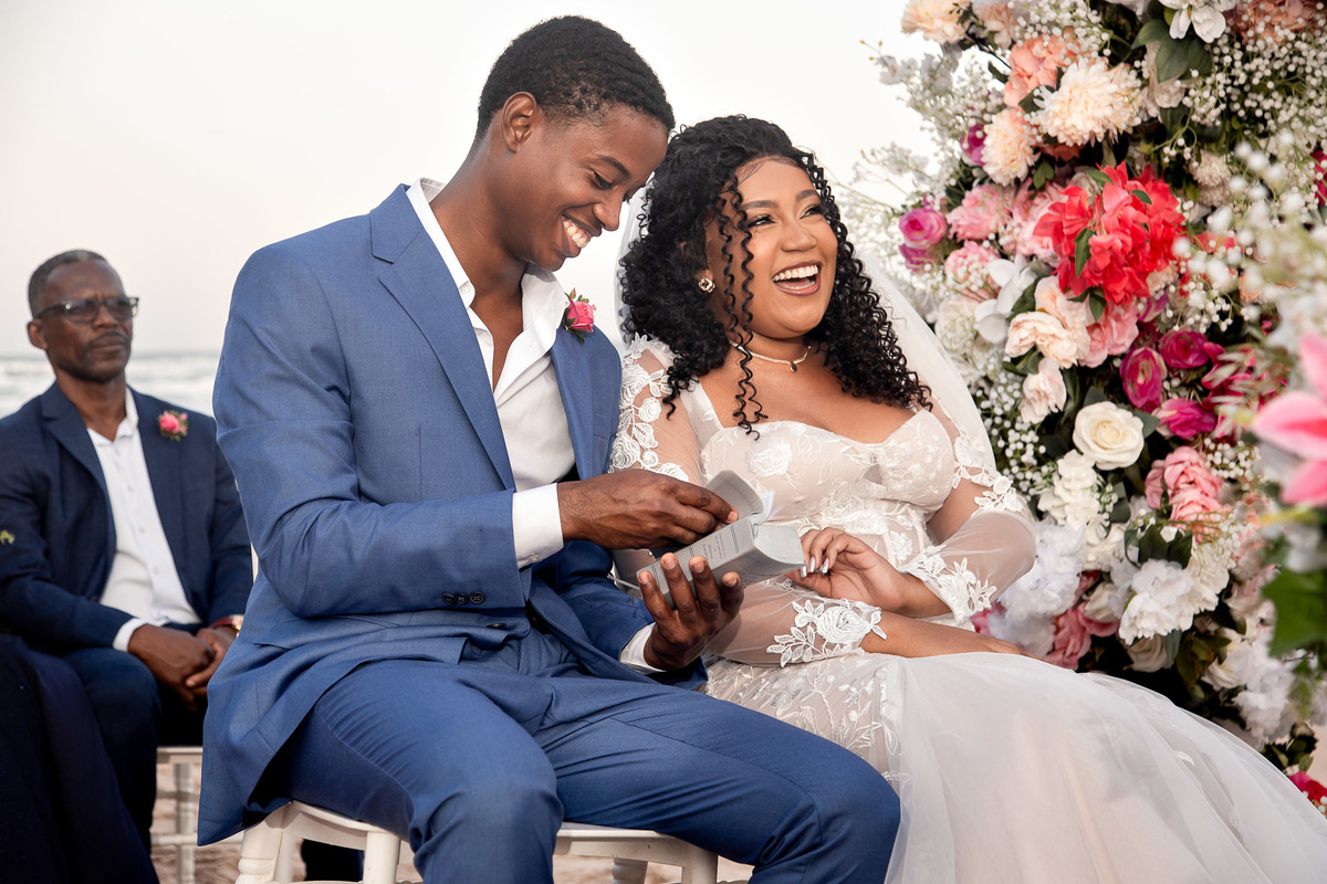 Noivos sorrindo próximos um do outro durante casamento na praia em Salvador