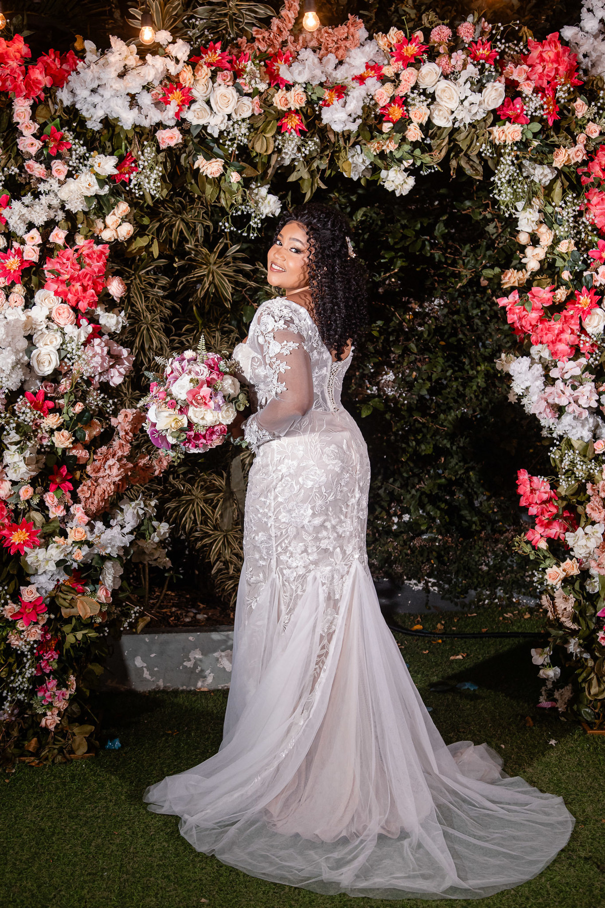 Noiva posando em frente à decoração floral da festa de casamento em Salvador