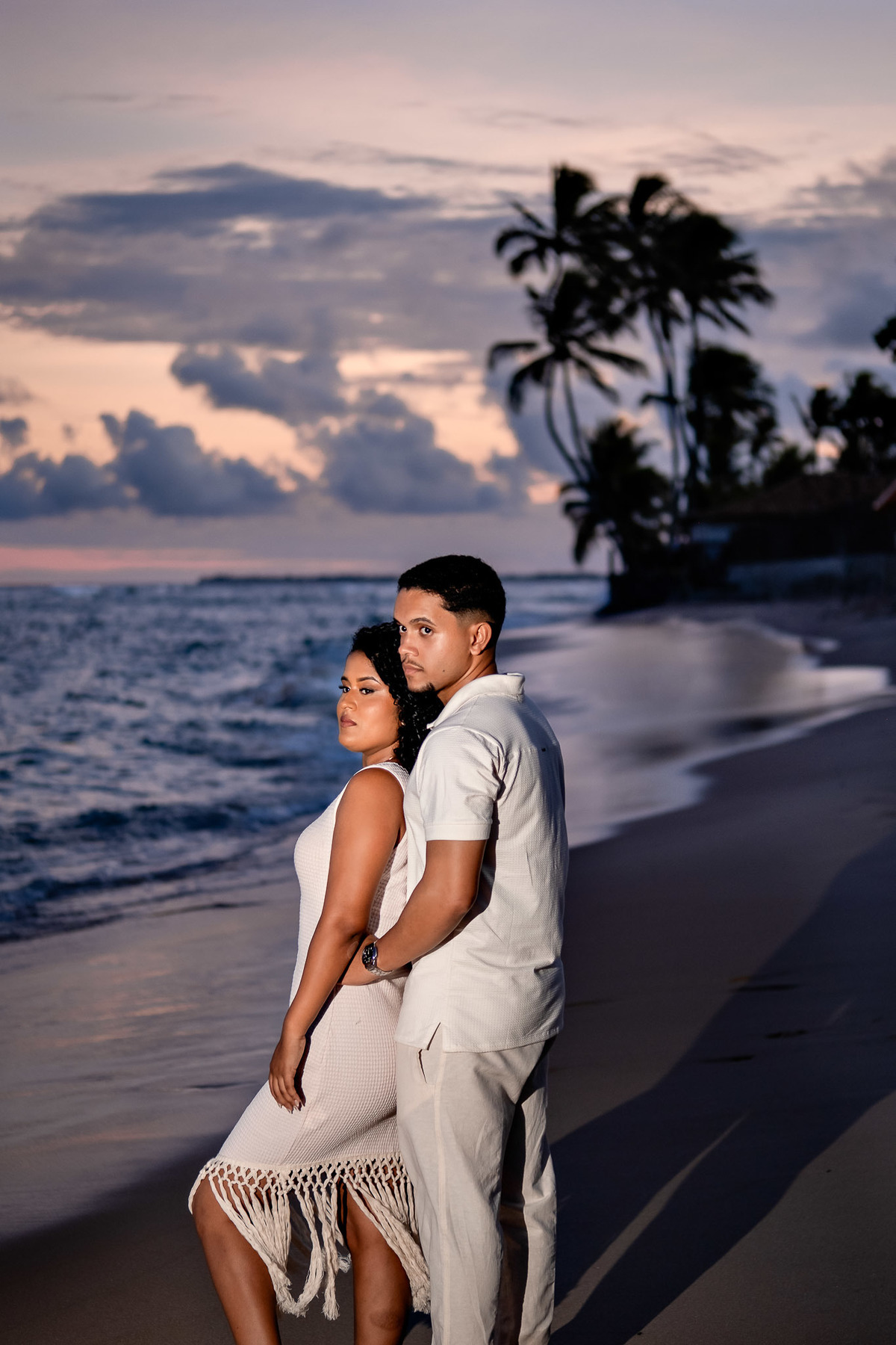 Silhueta do casal iluminada por lanternas no ensaio pré-casamento na Praia do Forte