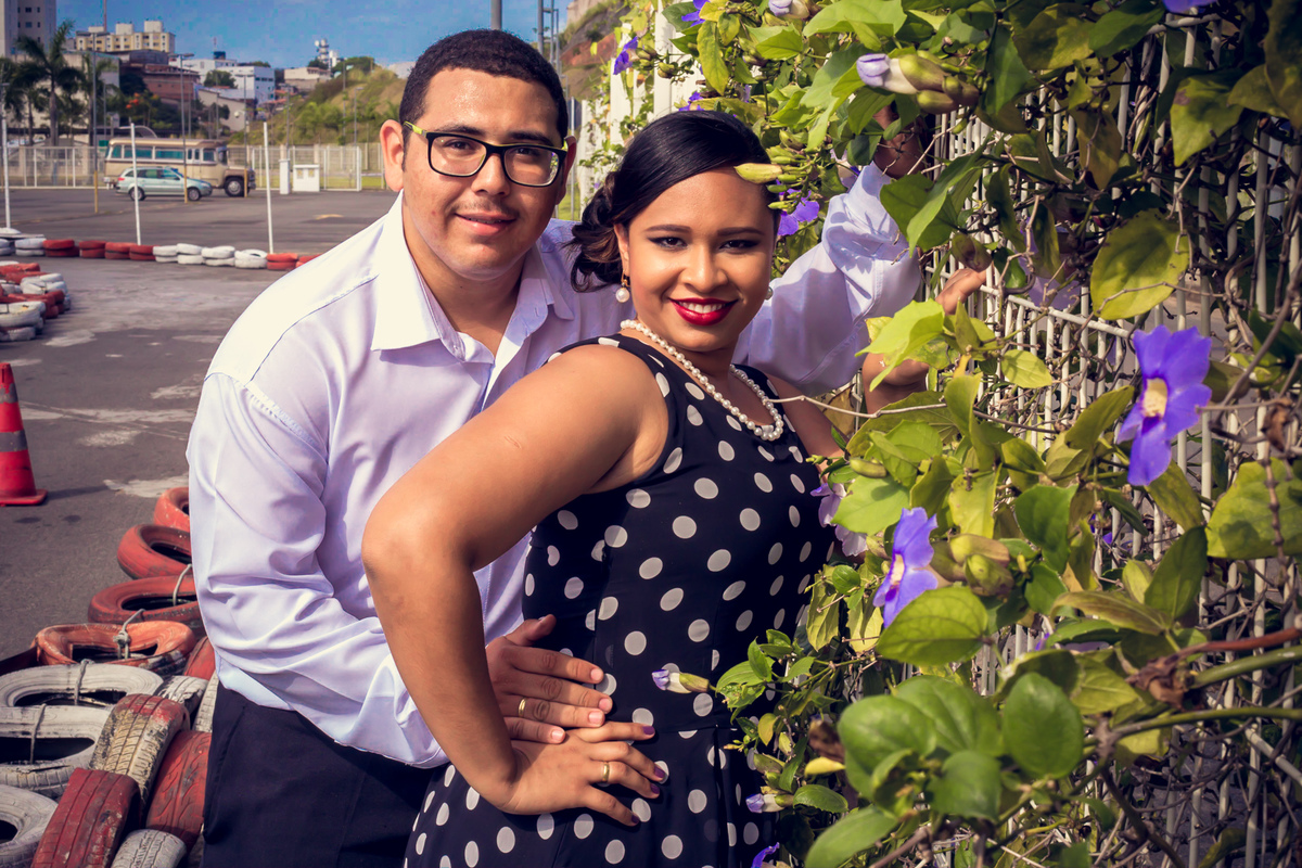 Casal abraçados perto de uma grade florida em pista de kart em Salvador