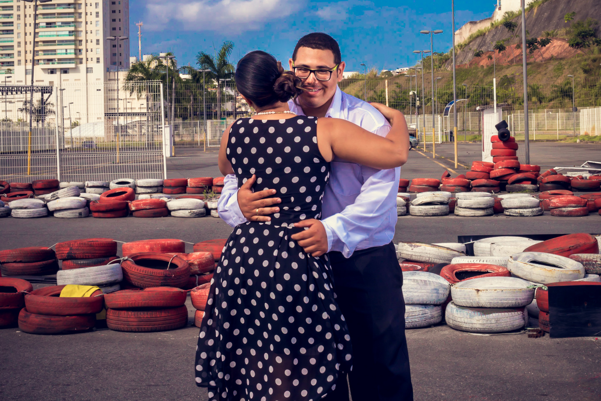 abraço apaixonado de casal com noivo olhando para a câmera em ensaio fotográfico