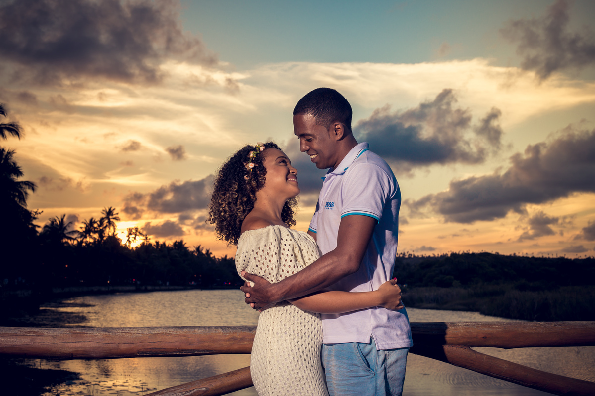Fotografia de Casal ao por do sol na praia do forte com casal se olhando